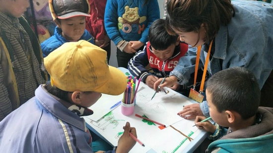 甘肃陇南文县安华镇花池小学的壹乐园儿童服务站里，孩子们和站长一起绘画，为儿童服务站增添色彩。