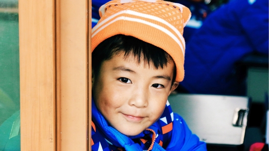 九寨沟地震灾区的孩子穿上了温暖包里的新棉衣，戴上了暖和的新帽子